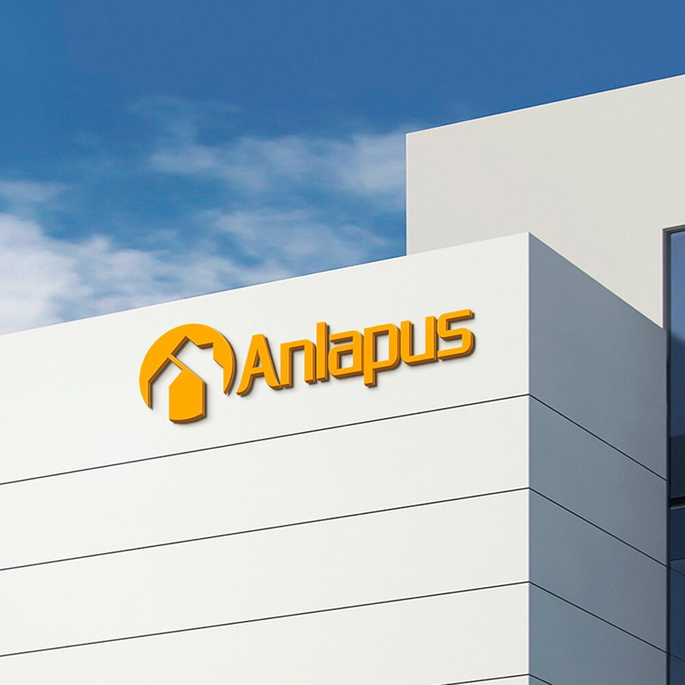 Orange Anlapus sign with house icon mounted on modern white office building facade under blue sky